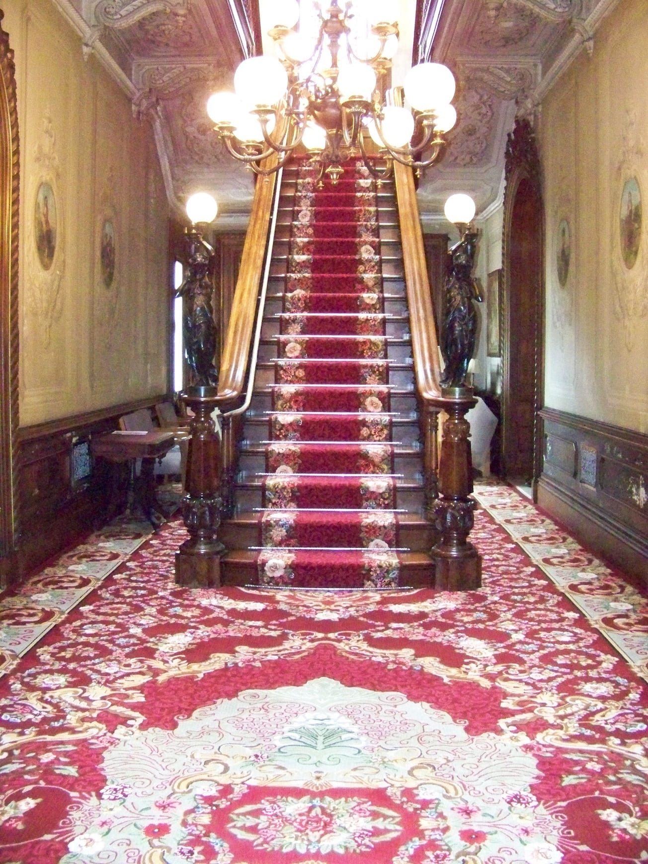 hallway view showing an area rug and carpeted staircase