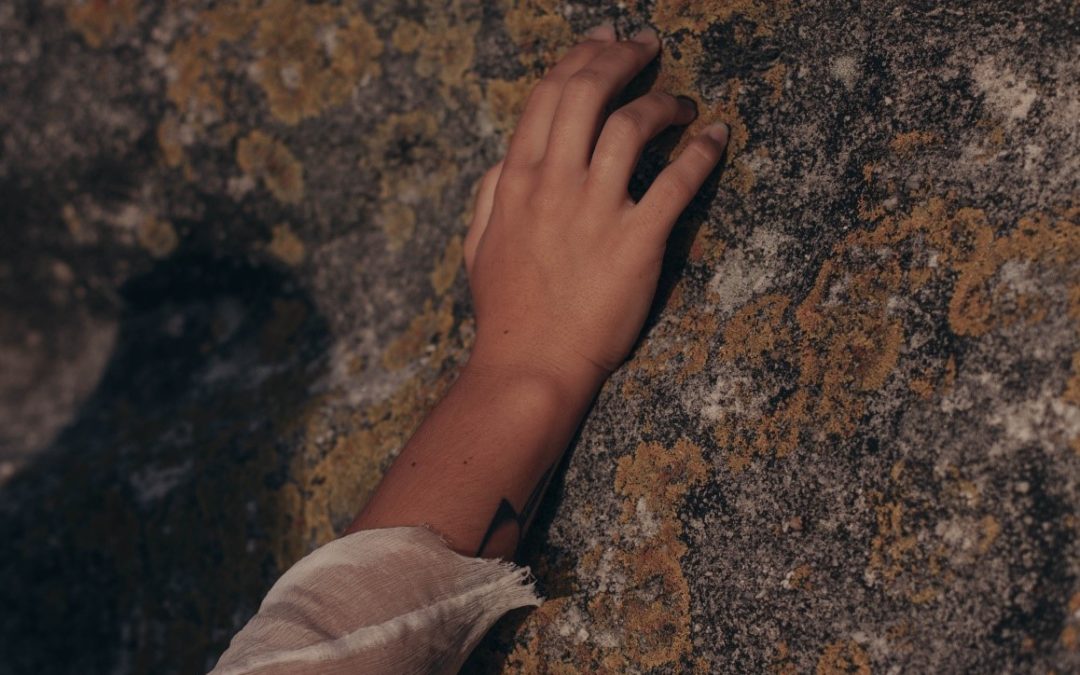 A child reaching out to touch mold growing on the wall