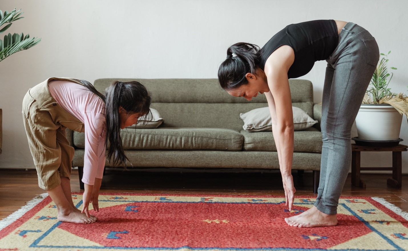 People stretching on the carpet in their living room